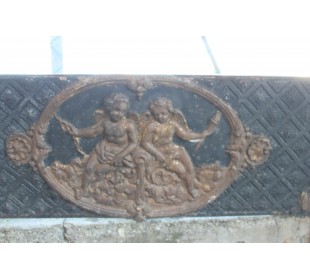 Antique cast iron insert with putti decorations and elegant background with floral tapisserie. 2