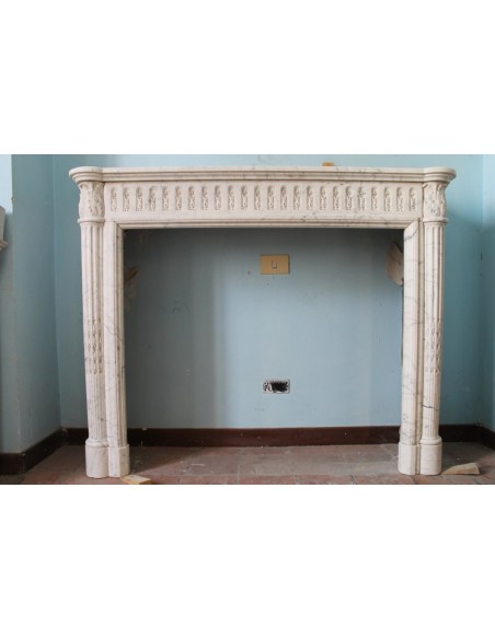 Original neoclassical fireplace surround carved in white Carrara marble, with fluted columns and Corinthians capitals