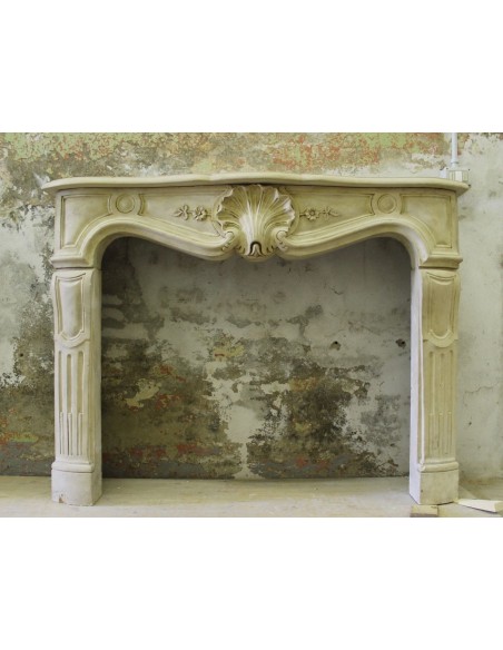 Antique stone fireplace, Louis XV “Transition” style, carved in Pierre Dorée and dating back to the 19th century.