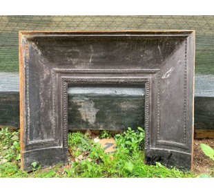 Antique cast iron insert designed to reduce the opening of a marble fireplace mantel.