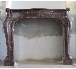 Art Nouveau-style fireplace mantel carved in Rouge Versailles marble. A rare, one-of-a-kind fireplace.