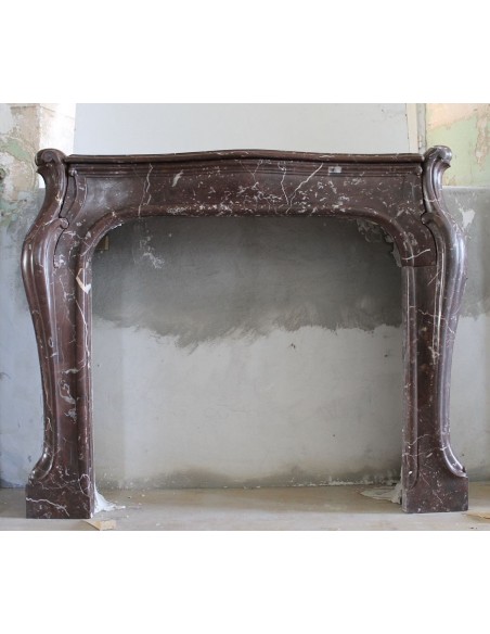 Art Nouveau-style fireplace mantel carved in Rouge Versailles marble. A rare, one-of-a-kind fireplace.