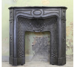 Antique cast-iron fireplace mantel with floral decorations, putti and pearls. This Larcher fireplace comes from Paris.
