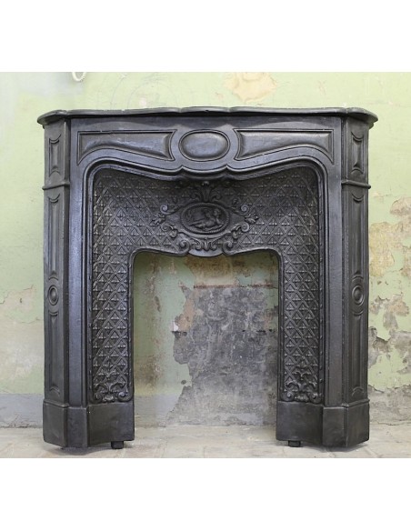 Antique cast-iron fireplace mantel with floral decorations, putti and pearls. This Larcher fireplace comes from Paris.
