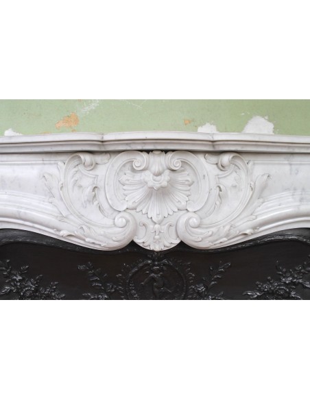 027 AG ANTIQUE LOUIS XV "ROSACES" FIREPLACE MANTEL CARVED IN WHITE CARRARA MARBLE WITH ITS OWN ORIGINAL FLORAL CAST IRON INSERT
