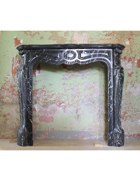 Antique Louis XV fireplace mantel carved in black Marquinia marble, with white veins.