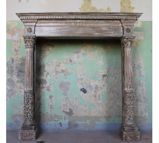 Antique oak fireplace mantel with neoclassical architectural details and column decoration.