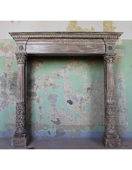 Antique oak fireplace mantel with neoclassical architectural details and column decoration.